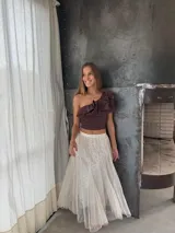 Pollera larga de tul color blanco con brillos plateados.