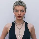 Collar plateado de acero inoxidable con doble cadena de eslabones gruesos. El collar tiene un dije colgante en forma de estrella.