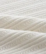 Musculosa de punto calado color blanco, de corte oversized y cuello redondo.