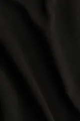 Buzo negro liso, de corte oversized con cuello redondo y hombros caídos. Presenta puños y bajo acanalados.