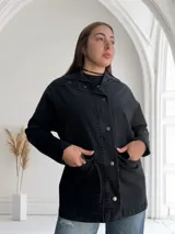 Sobrecamisa negra de jean con cuello camisero, cierre frontal con botones metálicos, bolsillos de parche en el pecho y corte recto.