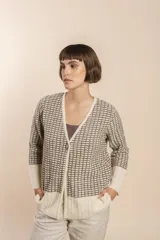 Cardigan tejido con efecto fantasia color crema. Una prenda de silueta amplia y cómoda. Tejido en 100% lana fina sin teñir.