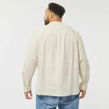 Camisa de manga larga color beige, con cuello mao y cierre frontal con botones.