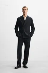 Blazer straight fit confeccionada en tejido de lana de origen italiano. Cuello con solapas de pico y manga larga acabada en puño con botones. Bolsillos de plastrón en pecho y cadera. Detalle de bolsillo interior. Bajo con aberturas en espalda. Cierre frontal de botonadura cruzada.