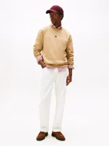 Buzo color beige de Tommy Hilfiger, de cuello redondo y corte clásico. Presenta el logo de la marca bordado en el pecho.