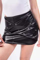 Minifalda negra de cuero sintético con diseño cruzado y ojales metálicos.