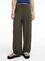Pantalón de lino color verde militar, de corte recto y pierna ancha, con pretina elástica y bolsillos laterales.
