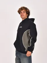 Buzo canguro negro con capucha, corte holgado y detalle de panel lateral en color verde oliva con ribete blanco. Presenta un estampado frontal con las letras "GTR".