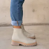 Botas cortas color marrón de cuero vacuno con suela track negra de goma. Presentan cierre lateral con cremallera YKK y puntera cuadrada.