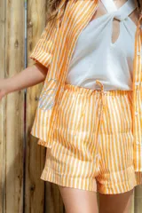 Short de corte relajado con elástico en la cintura, confeccionado en lino a rayas verticales color celeste y blanco.