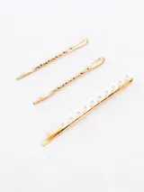 Set de tres broches dorados para el pelo, dos con diseño retorcido y uno con perlas.