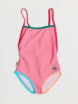 Traje de baño entero rojo con tirantes finos y espalda cruzada. Presenta un parche bordado con un monstruo en la parte inferior. Tiene ribetes en color borgoña y celeste en la parte superior, y ribetes en color naranja y verde en la parte inferior.