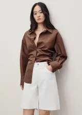 Short blanco de tiro medio con cierre de cremallera y botón, cinco bolsillos, diseño recto y bajo deshilachado.