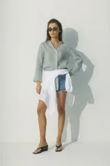 Camisa a rayas verticales blancas y negras, de corte recto y mangas largas.