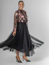 Falda estilo ballet core confeccionada en gasa negra con pequeños destellos que aportan brillo sutil y movimiento. Tiene cintura elastizada.