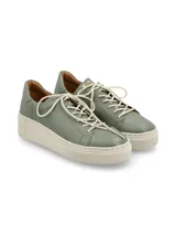 Sneaker Adelaida de cuero graneado color verde oliva, con cordones de algodón y suela elevada color crema.
