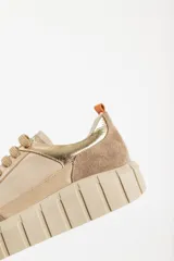 Zapatillas deportivas de cuero color beige con detalles en lila y amarillo.