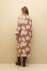 Vestido camisero midi color marrón con estampado de flores rosas, cinturón marrón y mangas largas.