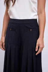 Pantalón palazzo plisado color azul marino, de tiro alto con bolsillos laterales y cierre frontal con botón.