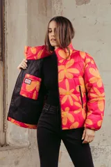 Campera puffer estampada con flores color naranja sobre fondo fucsia, de corte corto y cuello alto.