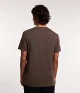 Remera de calce comfort confeccionada en algodón peruano de color marrón, con cuello redondo, mangas cortas y una pequeña estampa frontal con el texto 'not lost just exploring' y un gráfico de montañas.