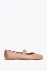 Zapato bailarina color rosa viejo, de efecto satinado, con punta cuadrada, tira elástica y lazo decorativo en la parte delantera.