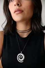 Collar con dije plateado en forma de espiral y cordón negro encerado.