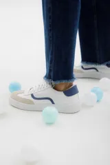Zapatillas plateadas con cordones blancos y suela blanca.