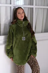 Buzo verde de peluche corderito con cierre parcial en el cuello y logo cuadrado en el pecho.