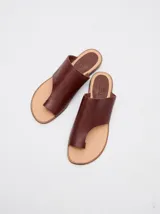 Sandalias de cuero color marrón con tira ancha sobre el empeine y abertura para el dedo gordo.