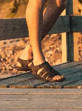 Sandalias de cuero color marrón chocolate, tipo fisherman, con tiras entrelazadas y ajuste con velcro en el tobillo.