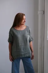 Blusa verde militar de lino con cuello redondo, mangas 3/4 con trabillas y bolsillo en el pecho con apliques de lentejuelas.