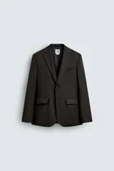 Blazer negro de lana con corte regular fit. Tiene cuello con solapas de muesca, manga larga con puños abotonados, bolsillos de vivo en el pecho y de solapa en la cadera, bolsillo interior, aberturas en la espalda y cierre frontal con botones.