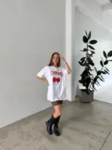 Remeron de algodón blanco con gráfico de cerezas y texto colorido, de corte suelto y cómodo.