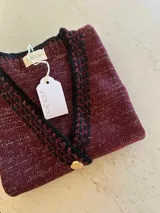 Chaleco tejido color marrón con detalles de lurex, escote en V, bordado con botones, terminaciones en crochet y bordados hechos a mano con lana merino.