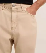 Pantalón baggy negro de sarga de algodón, con cintura fija con trabillas, botón contrastante y cierre por cremallera oculto, bolsillos laterales y traseros. Modelo holgado de corte recto y ancho.