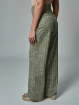 Pantalón de lino color ladrillo con estampado a cuadros blancos, de corte palazzo y tiro alto.