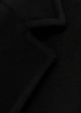 Abrigo negro de corte recto con doble botonadura, cuello con solapa de pico, bolsillos frontales con solapa y forro interior.