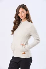 Campera tejida de abrigo color beige, con cierre frontal, cuello alto y bolsillos laterales.