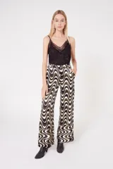 Pantalón palazzo con estampado de ondas en tonos blanco, negro y dorado.
