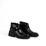 Bota corta de cuero color marrón con cierre lateral, suela de goma negra y hebilla decorativa.