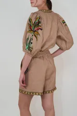 Short de lino color rosa pálido con estampado de tigres y vegetación en tonos tierra. Tiene cintura elastizada con cordón ajustable.