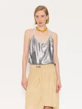 Top corto plateado con breteles finos y espalda descubierta con flecos cruzados.