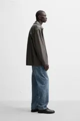Pantalón de jean gris de corte recto, con cinco bolsillos, efecto lavado y cierre frontal con botones.