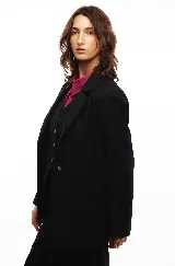 Blazer negro entallado de tela liviana con botón para cerrar y tres botones en cada manga.