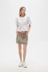 Minifalda de jean color beige con estampado animal print en tonos marrones.