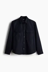 Sobrecamisa azul marino de tejido afieltrado con cuello, botones adelante y canesú en la espalda. Tiene bolsillos superiores con solapa, puños abotonados y bajo redondeado.