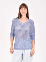 Buzo de tejido de punto calado color negro, con escote en V y mangas 3/4.