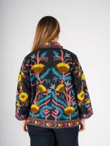 Chaqueta negra con bordado floral multicolor, de corte recto y mangas largas.