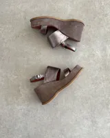 Sandalias de cuero vacuno color marrón, con plataforma y tiras cruzadas.